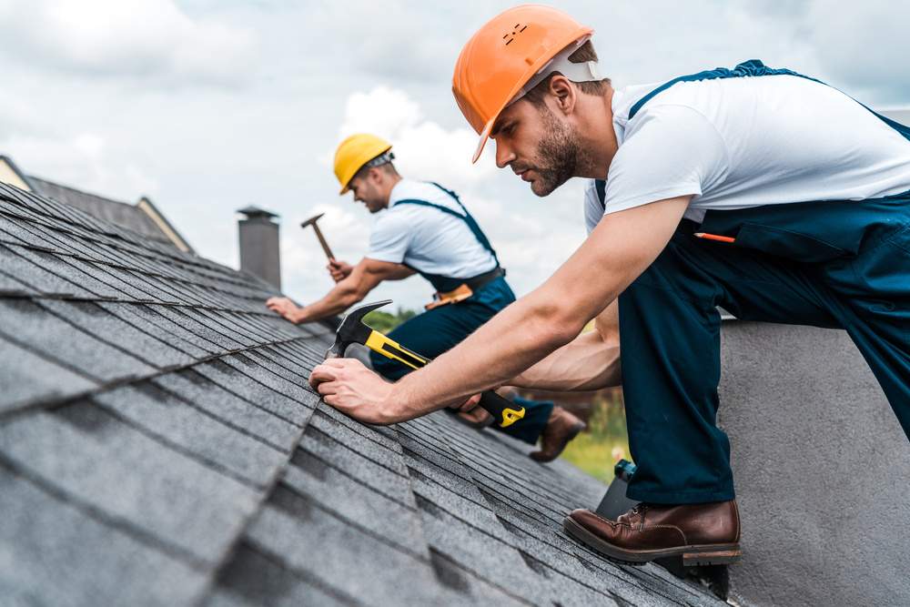 workers with yellow helmet roof irepairs